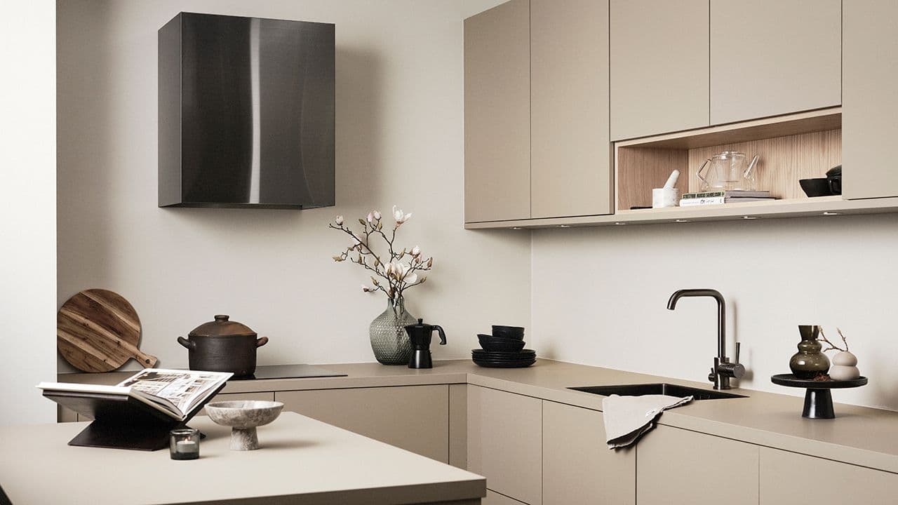 Veggmontert kjøkkenventilator i beige kjøkken.