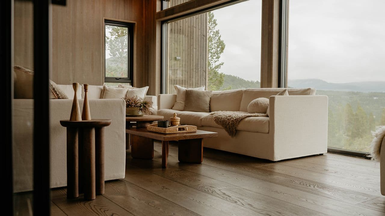 Stue med mørkt gulv og gylne farger.