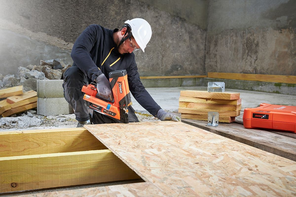 håndverker fester kryssfinerplate med spikerpistolen IM90Xi fra Paslode