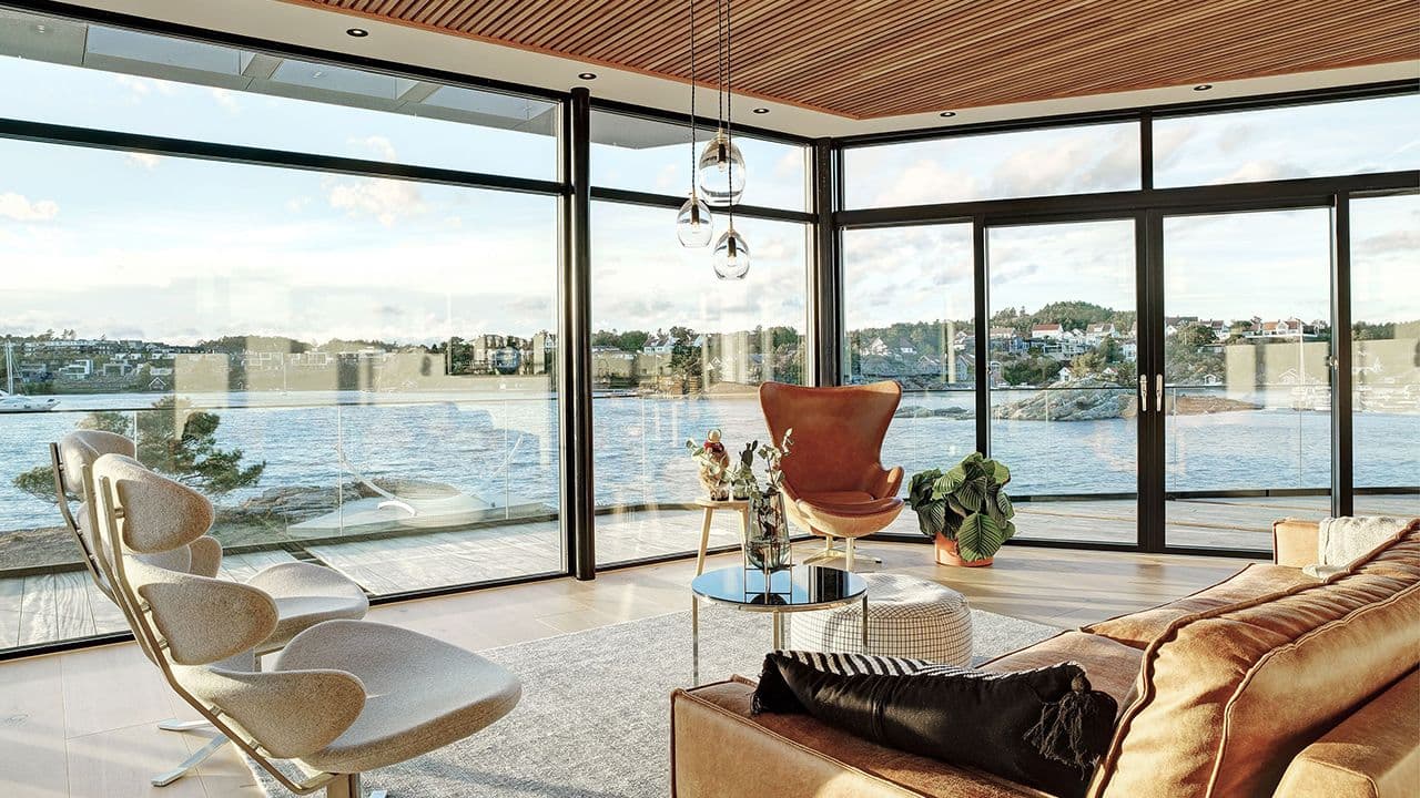 Stue med havutsikt med store vinduer.