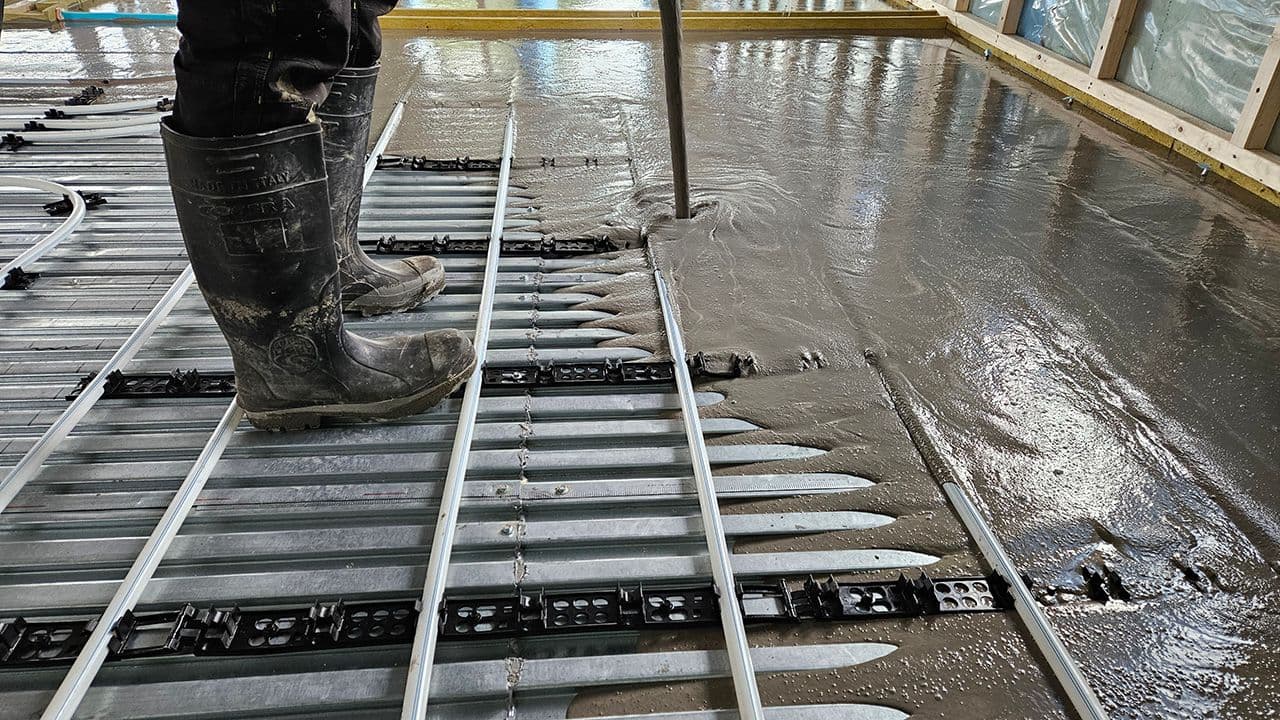 Person som heller avrettingsmasse på svalehaleplater.