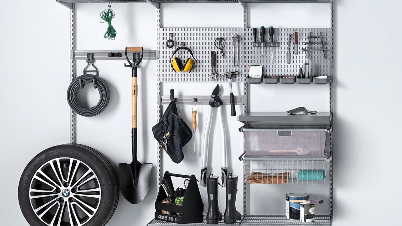 Veggsystem som garasjeinnredning for oppbevaring av verktøy og bildekk.