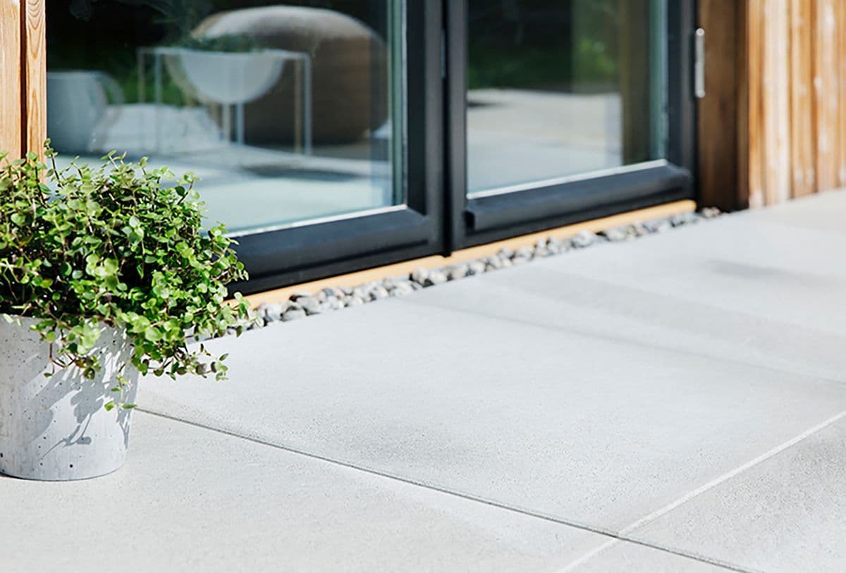 Funkishus med store hvite heller på uteplassen.