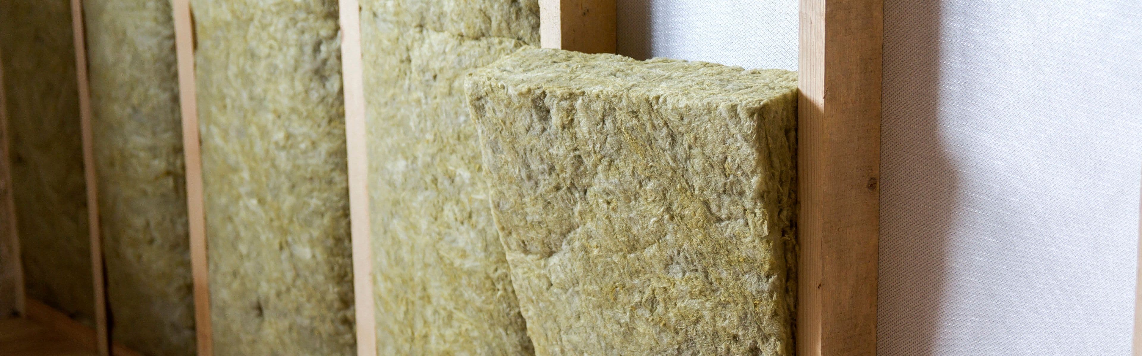 Isolasjon av steinull som er satt inn i innvendig vegg for etterisolasjon.