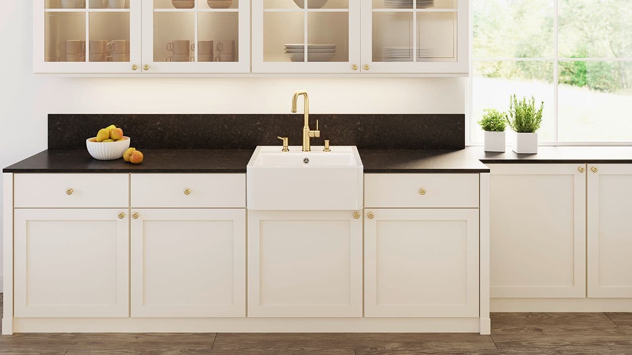 Porselensvask montert direkte på kjøkkenskap i landlig kjøkken.