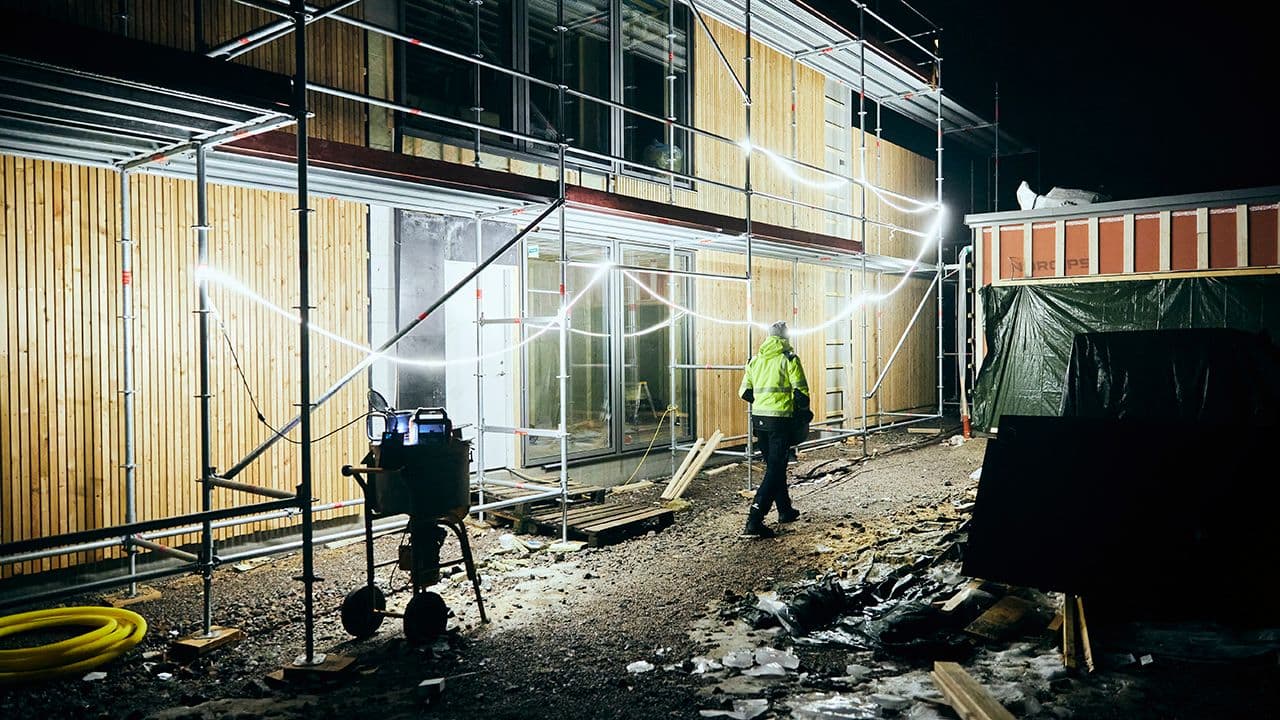 Mareld Sunlit LED-lyslister hengt opp i stillas ute på byggeplass.