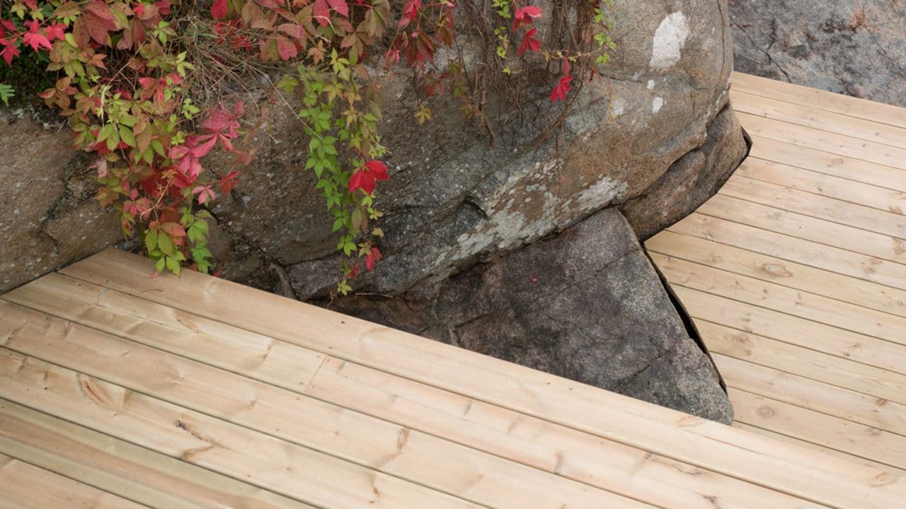 Utetrapp av trykkimpregnerte terrassegulv som følger terrenget i hagen.