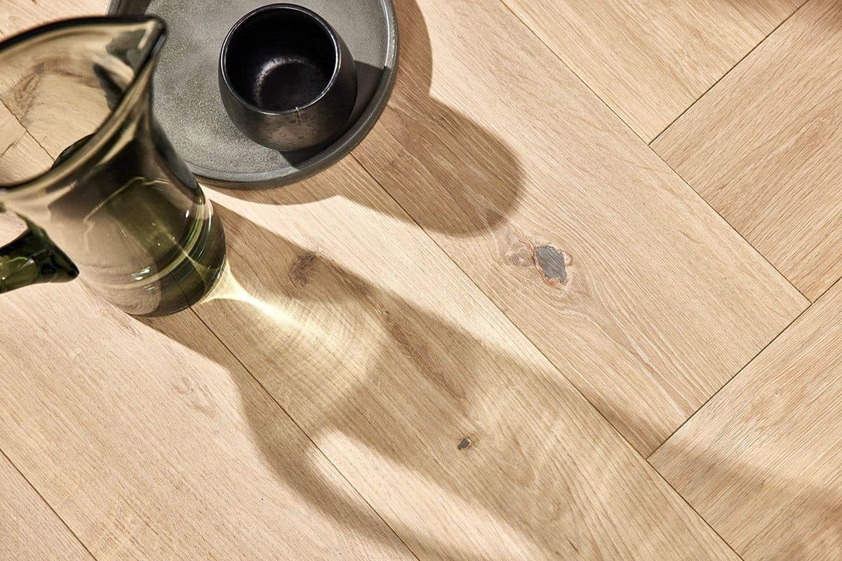 Grønn glassmugge med vann står på et parkettgulv