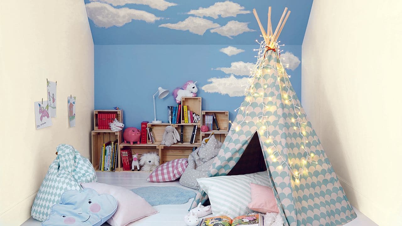 Barnerom med tipitelt. Bakveggen og taket er malt blått med skyer på.