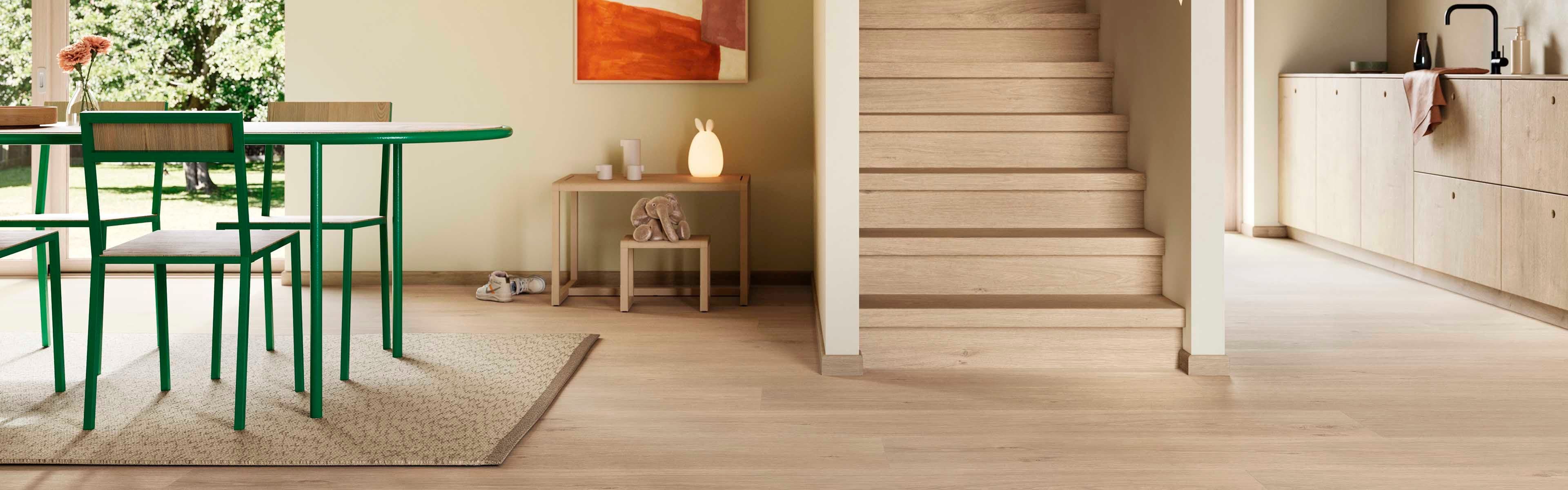 Åpen stue-kjøken-løsning med matchende trapp og gulv.