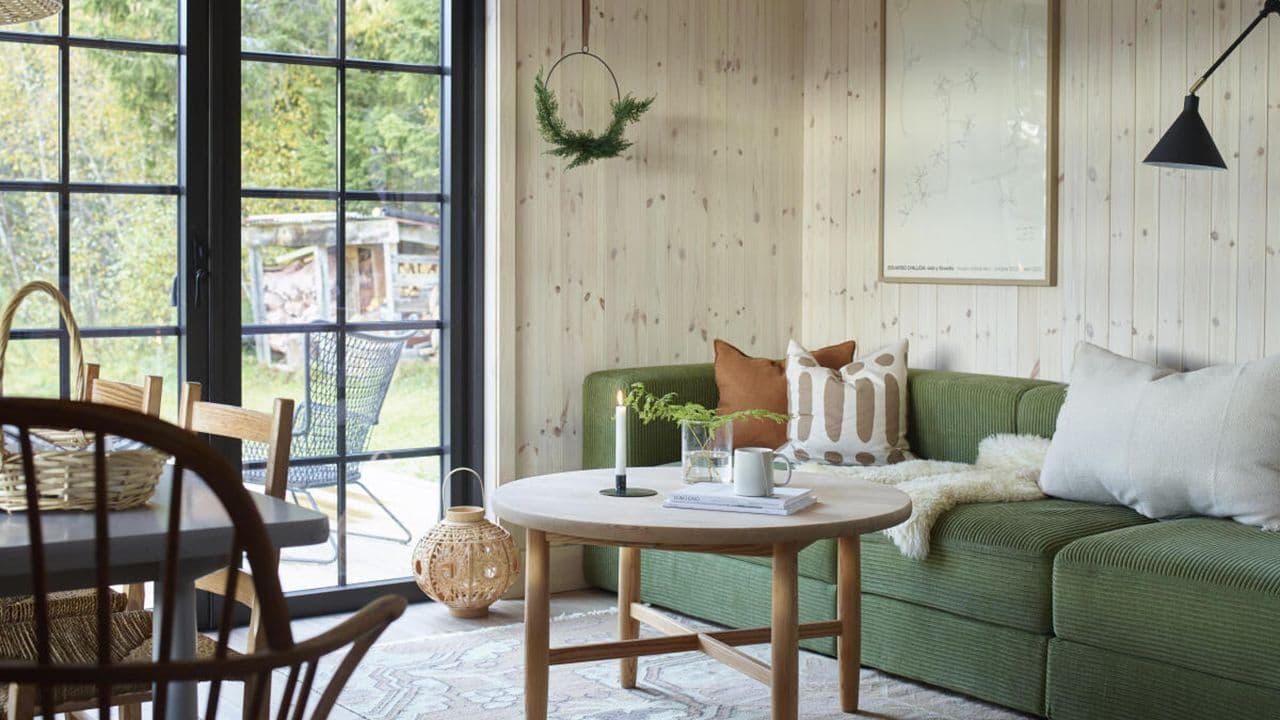 Gammel hytte som er pusset opp med ny lys trepanel i furu.