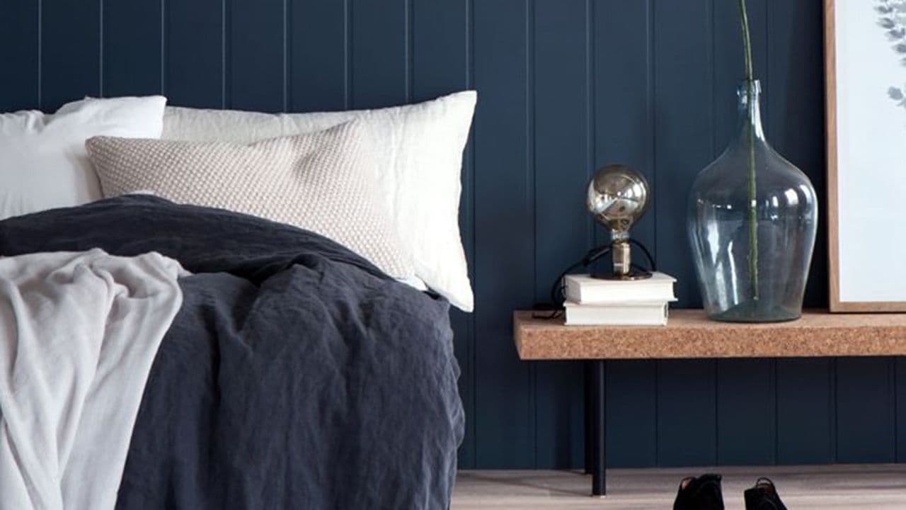 Soverom med mørkeblå veggplater.