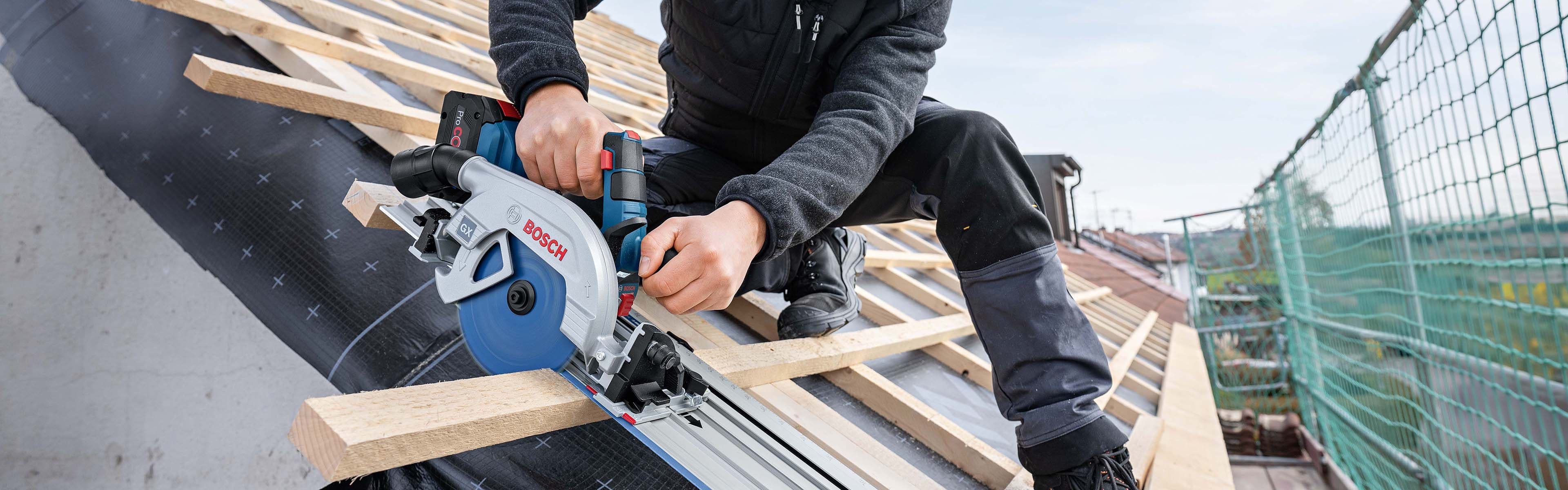 snekker sitter på et tak og kapper med sirkelsagen Bosch GKS 18V-57-2 GX