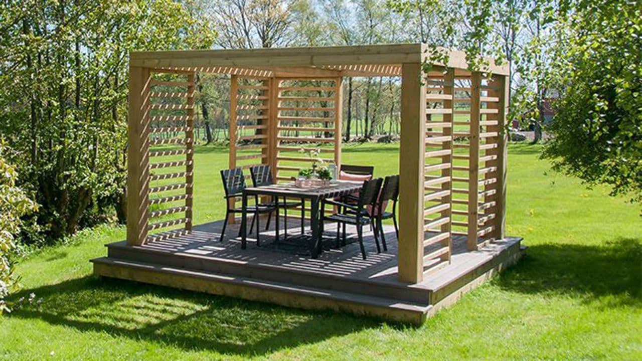 Pergola med spisegruppe i hage.