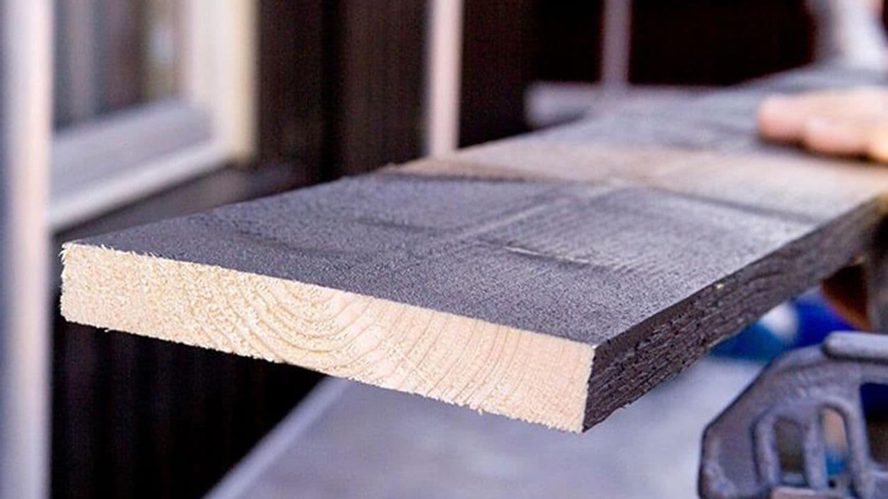 Nærbilde av ferdig malt utvendig kledning som kuttes.