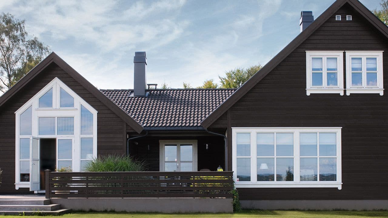 Hus malt med matt svart maling i fargen JOTUN 1434 Labrador og staffasje i JOTUN 1001 Eggehvit.