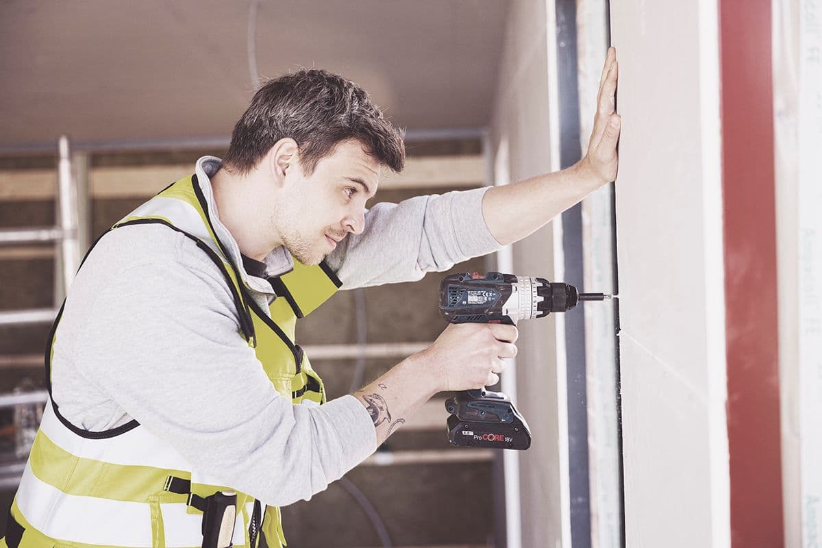 snekker skrur fast gipsplater med drill