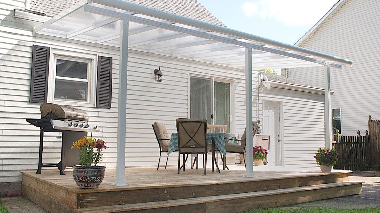 Hvit pergola på terrasse med grill og spisebord.