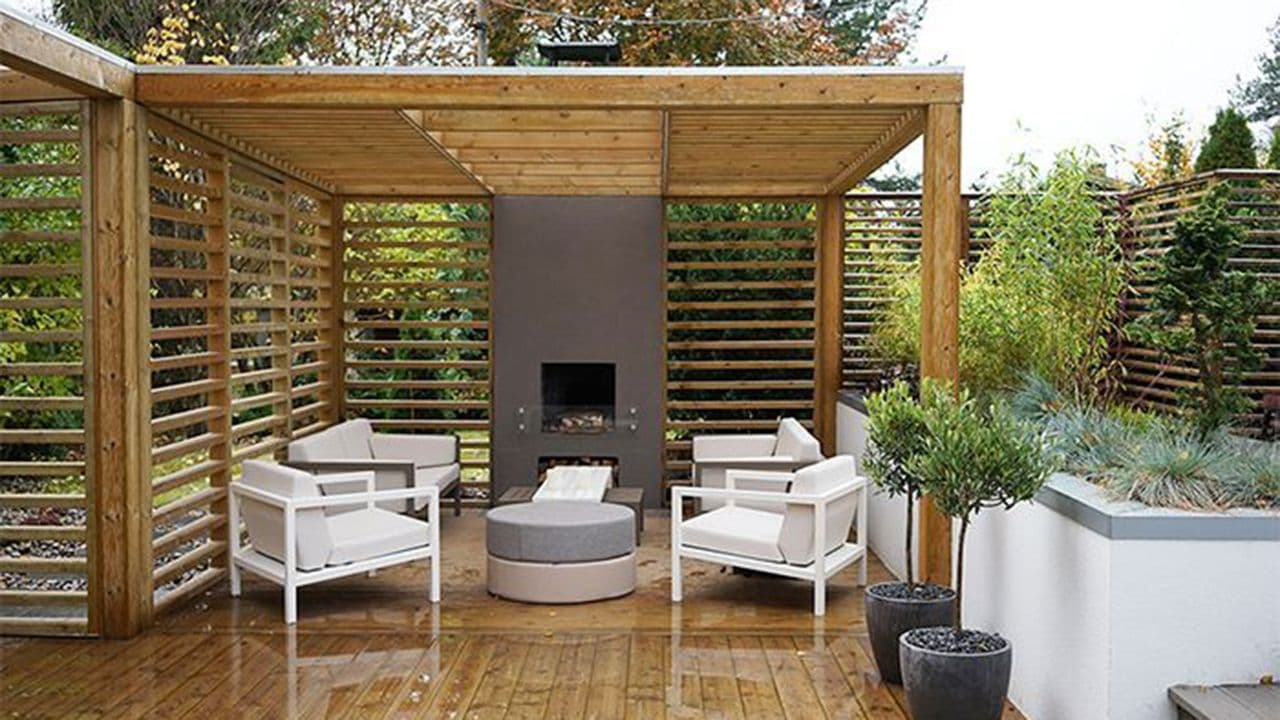 Pergola med sittegruppe på terrasse med peis.