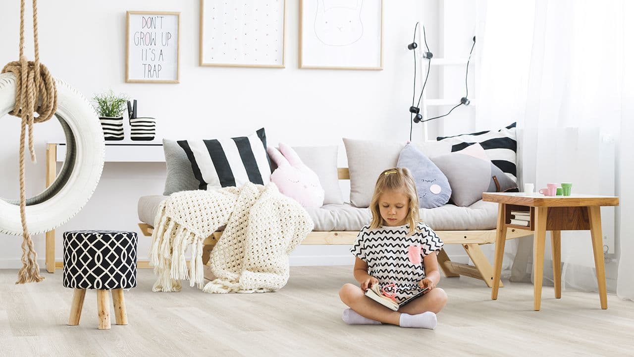 barn sitter på et stuegulv av kork