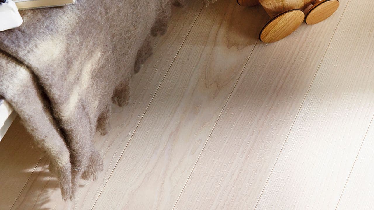 Nærbilde av gulv i ask på soverom med hotellfølelse.