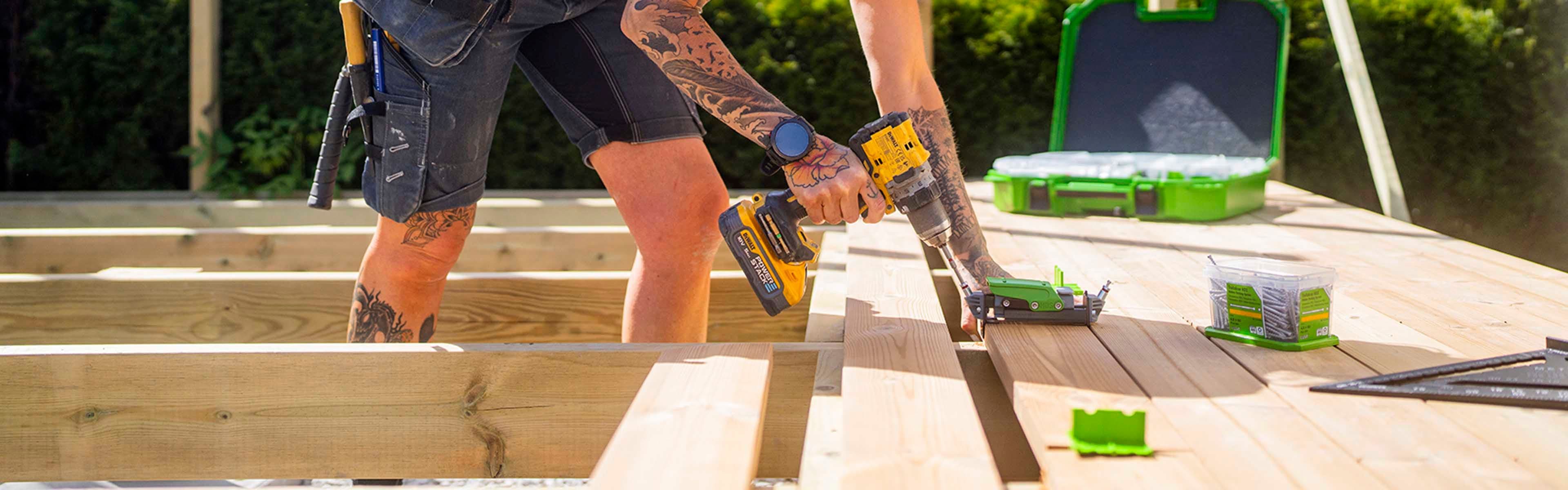 Kvinnelig håndverker viser skjult innfesting av terrassebord.