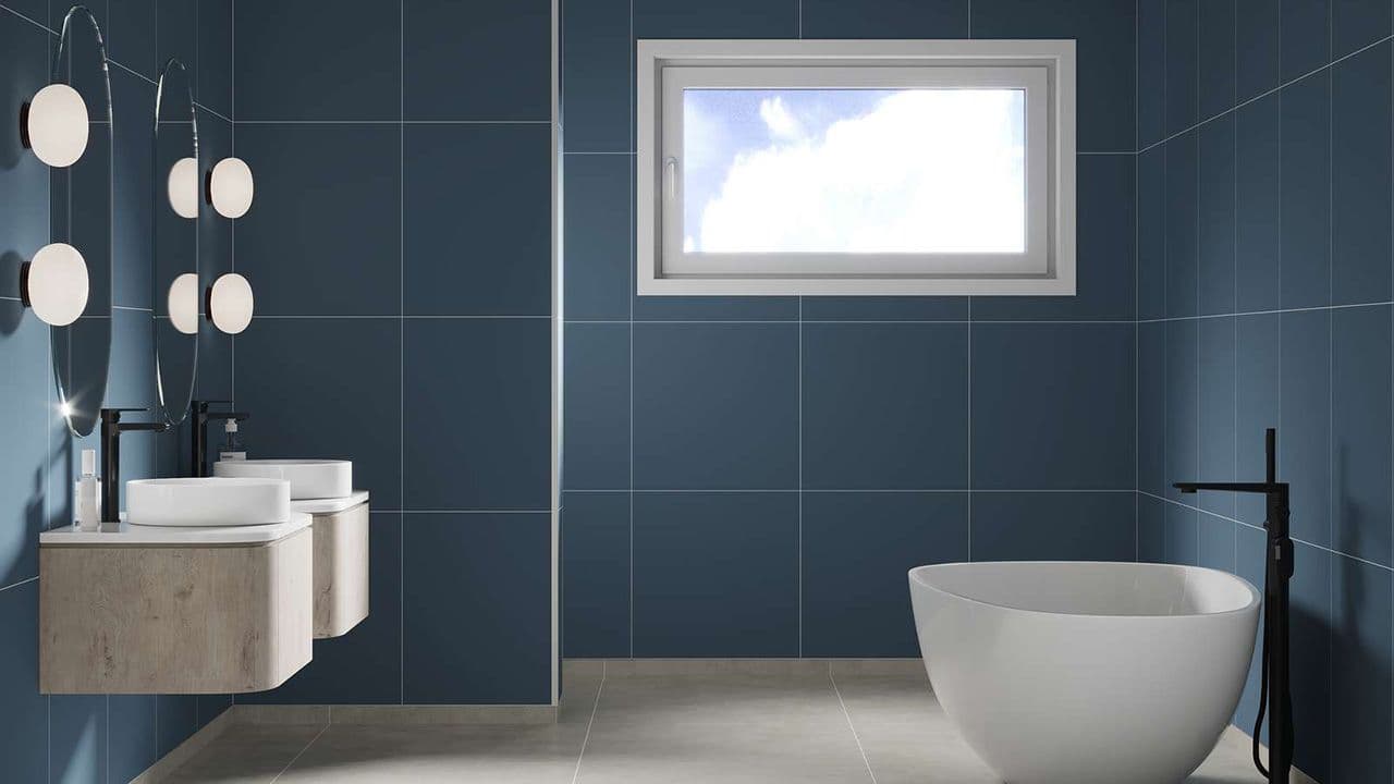 Bad med hvite baderomsbøler og blå baderomsplater med flisemønster.