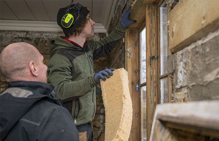 to menn isolerer et gammelt hus