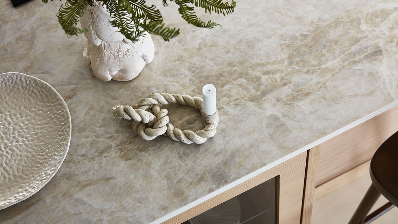 Beige steinplate som benkeplate på kjøkken i lys eik.