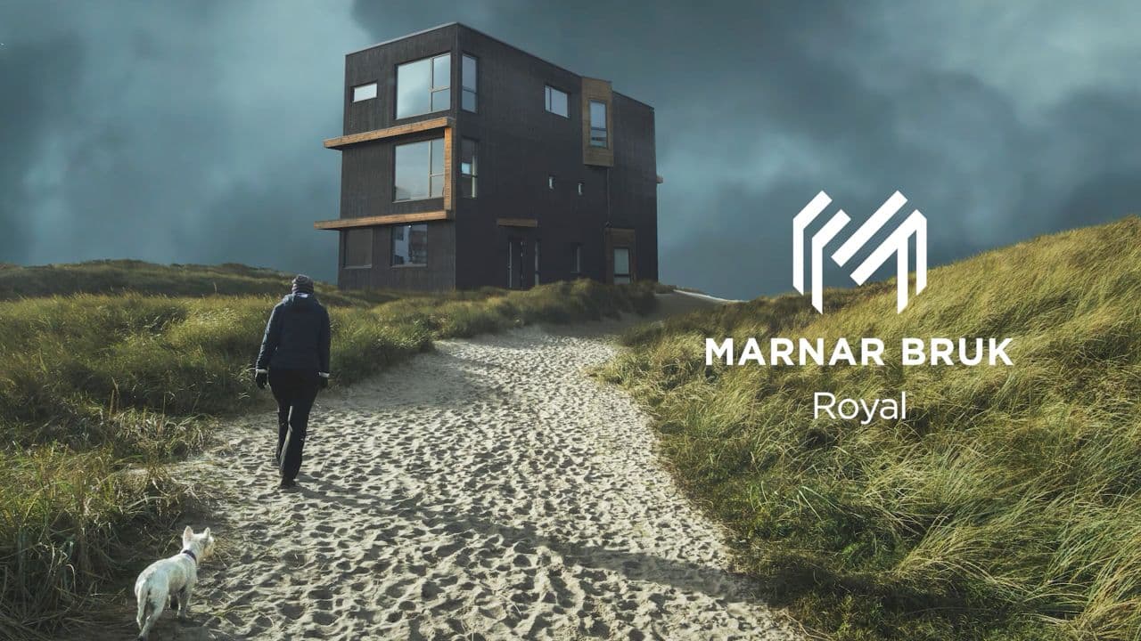 Mann og hund som går opp mot hus med stående kledning.