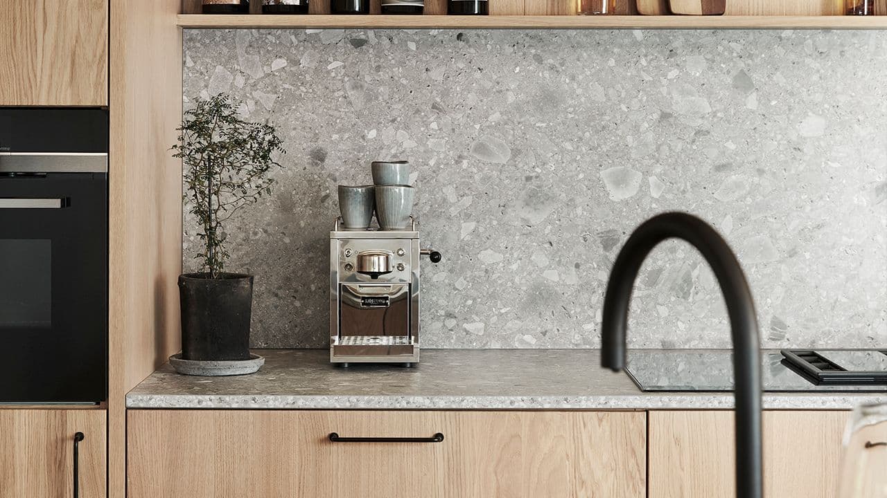 Lyst eikekjøkken med grå benkeplate laminat.