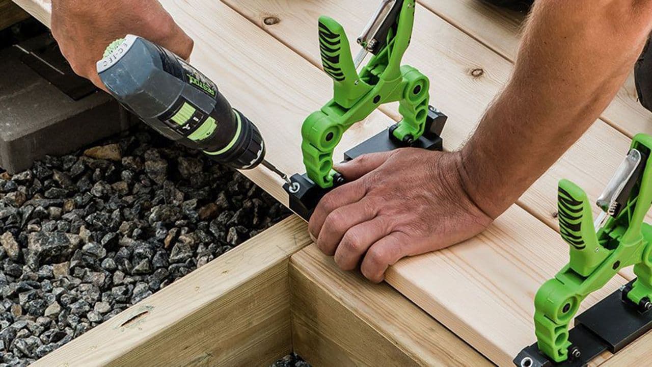 Håndverker som bygger platting med skjulte skruer verktøy.